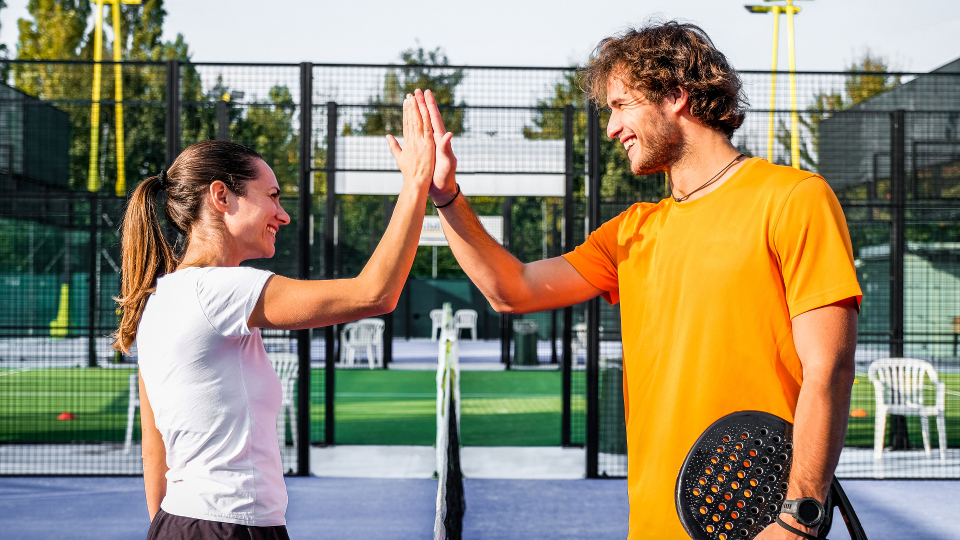 Speler en trainer geven elkaar een high-five op de baan